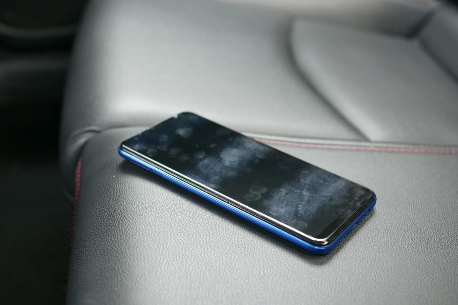 A cell phone sitting on a leather car seat