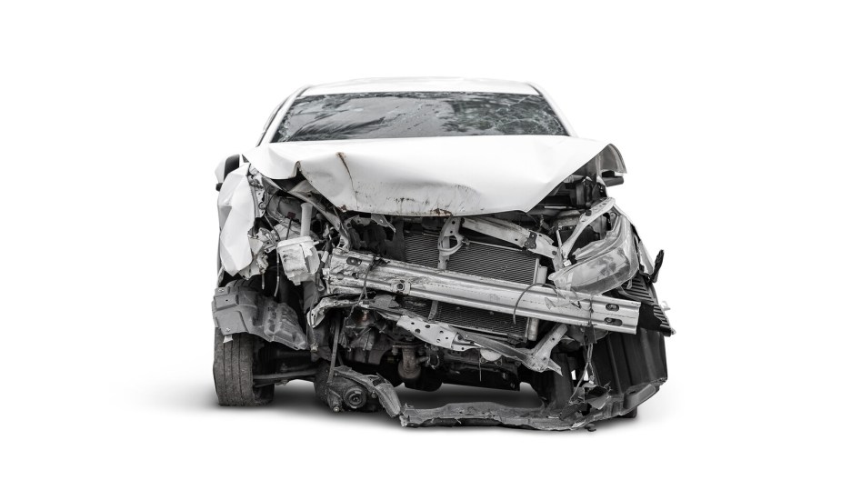A light colored car shown in direct front view on white background after a head-on collision