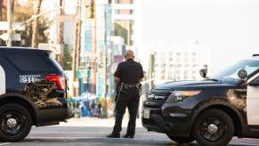 An LAPD officer holds a roadblock after a an armored vehicle rammed a stolen truck to stop a police chase.