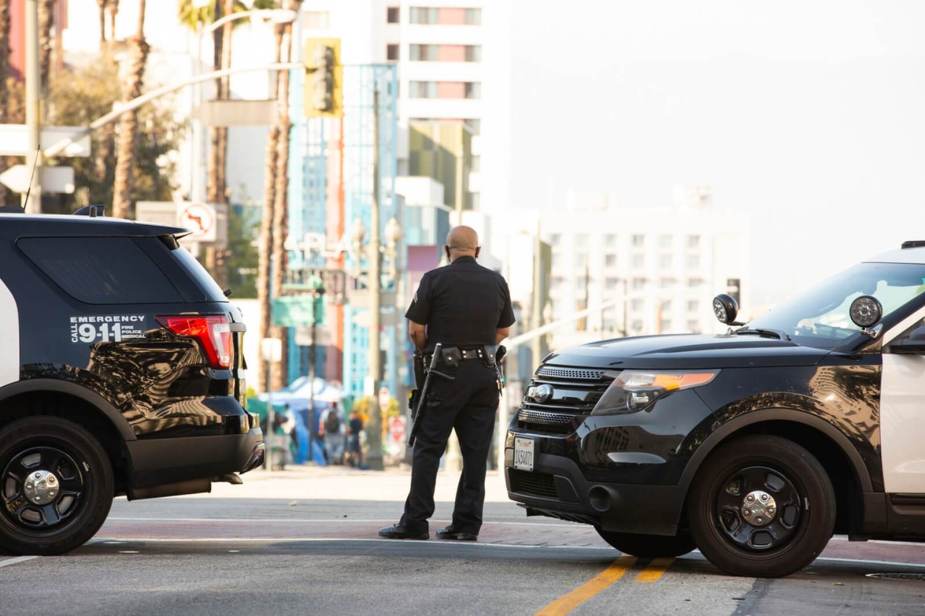 An LAPD officer holds a roadblock after a an armored vehicle rammed a stolen truck to stop a police chase.