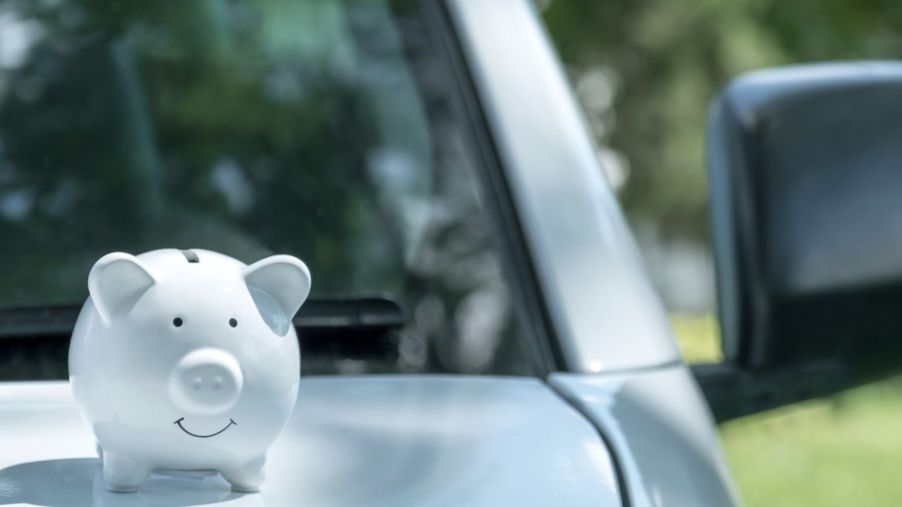 A white piggy bank on a car hood