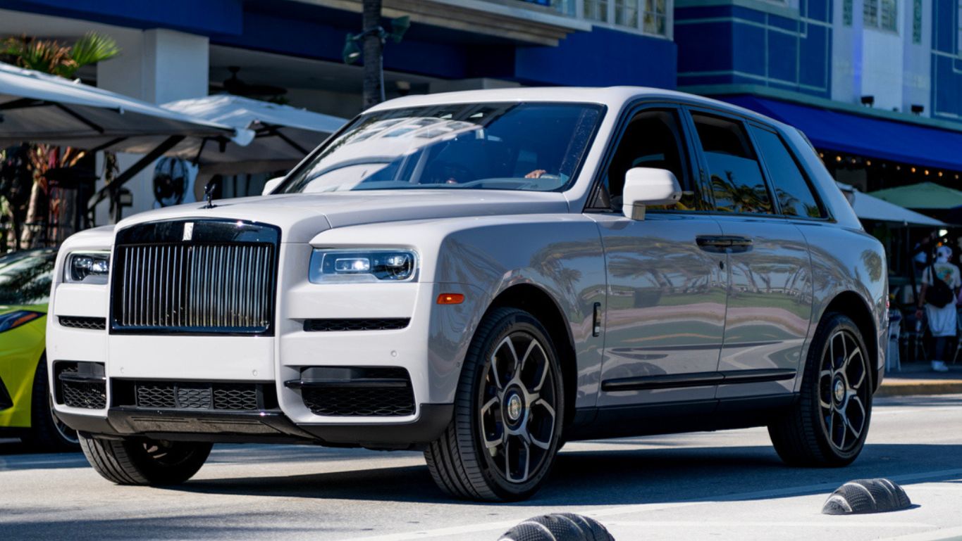A white Rolls-Royce Cullinan parked in left front angle view