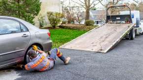 A tow truck operator gets ready to load a car, like the truck that had an altercation with a Waymo cab.