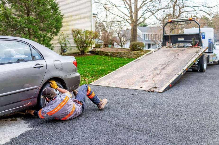 A tow truck operator gets ready to load a car, like the truck that had an altercation with a Waymo cab.