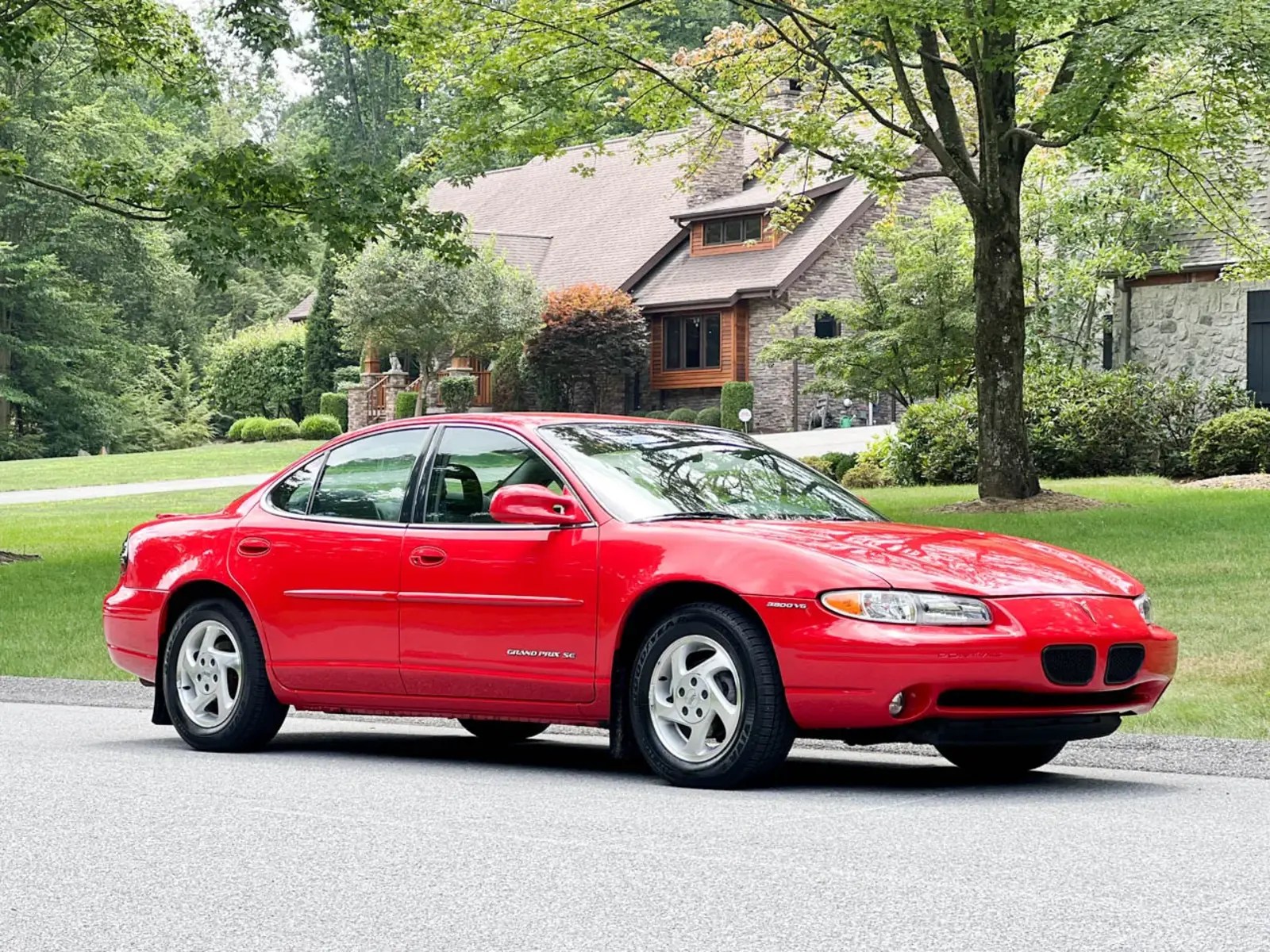 A red 1998 Pontiac Grand Prix parked in right profile angle view