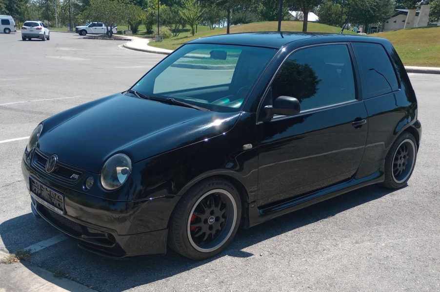 The grille and front of a subcompact Volkswagen Lupo hot hatch car, in a parking lot.