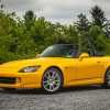 A yellow 2005 Honda S2000 parked in left front angle view