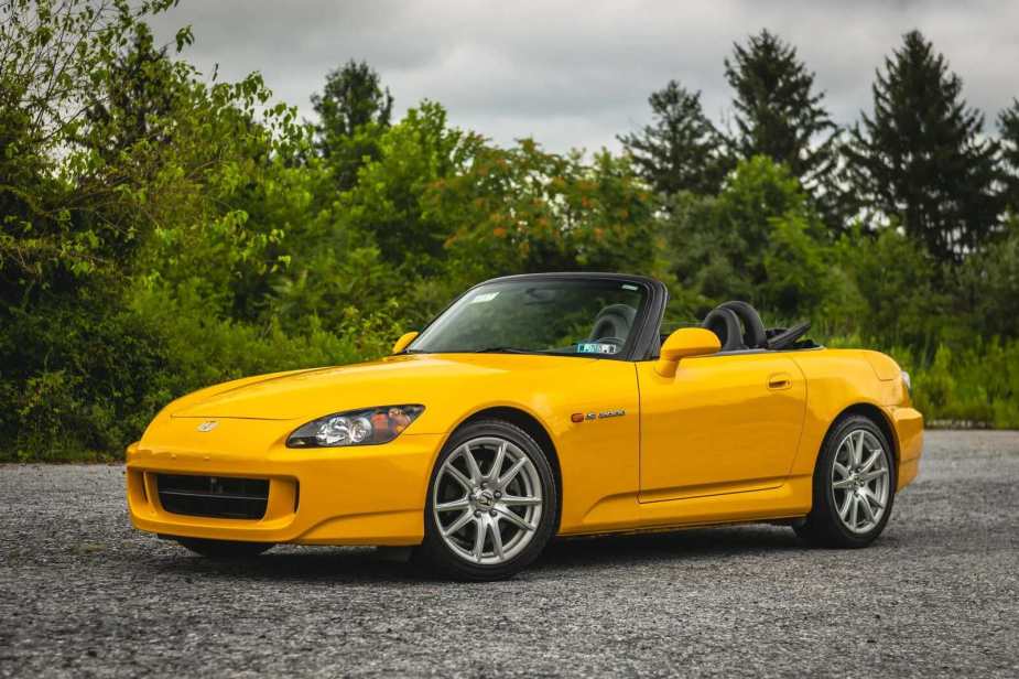 A yellow 2005 Honda S2000 parked in left front angle view