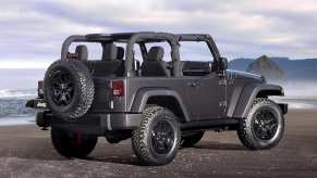 A grey 2014 Jeep Wrangler parked in right rear angle view