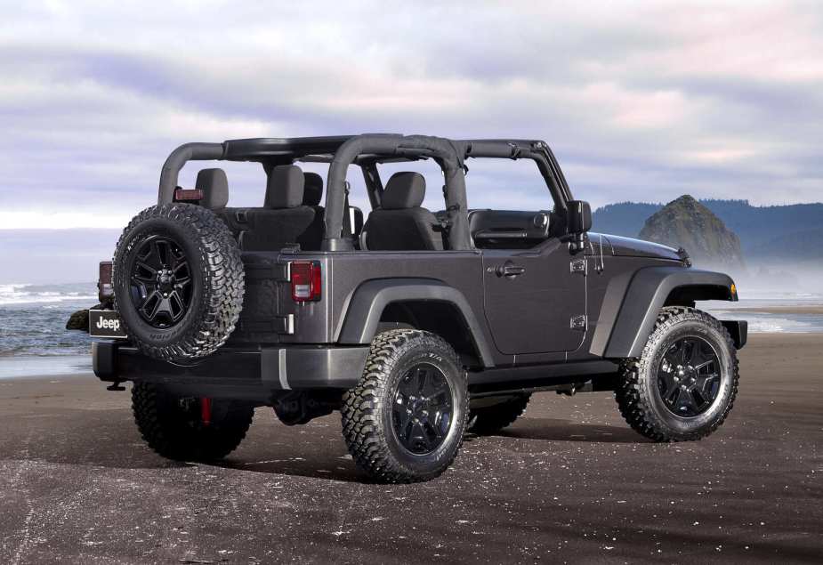 A grey 2014 Jeep Wrangler parked in right rear angle view