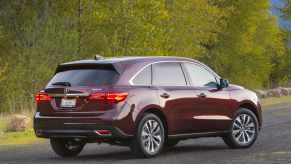 A red 2016 Acura MDX parked in right rear angle view