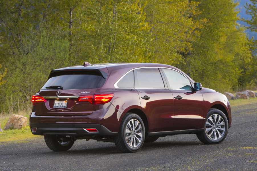A red 2016 Acura MDX parked in right rear angle view
