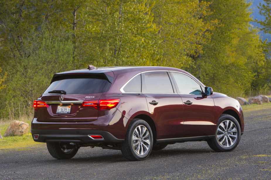 A red 2016 Acura MDX parked in right rear angle view