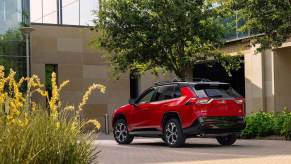 A 2025 Toyota RAV4 PHEV XSE parked by a large home.