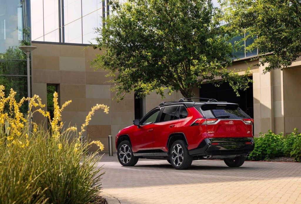 A 2025 Toyota RAV4 PHEV XSE parked by a large home.