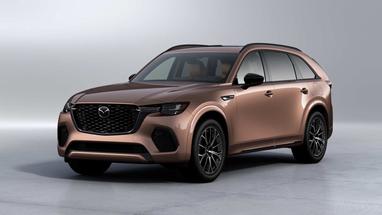 A copper colored 2025 Mazda CX-70 Hybrid parked in left front angle view