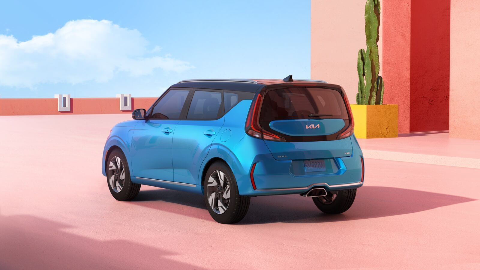 A bright-blue Kia Soul against a colorful background. 