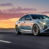 A Cadillac CT4-V Blackwing and CT5-V Blackwing drive beneath a colorful sunset.
