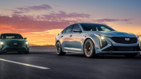A Cadillac CT4-V Blackwing and CT5-V Blackwing drive beneath a colorful sunset.