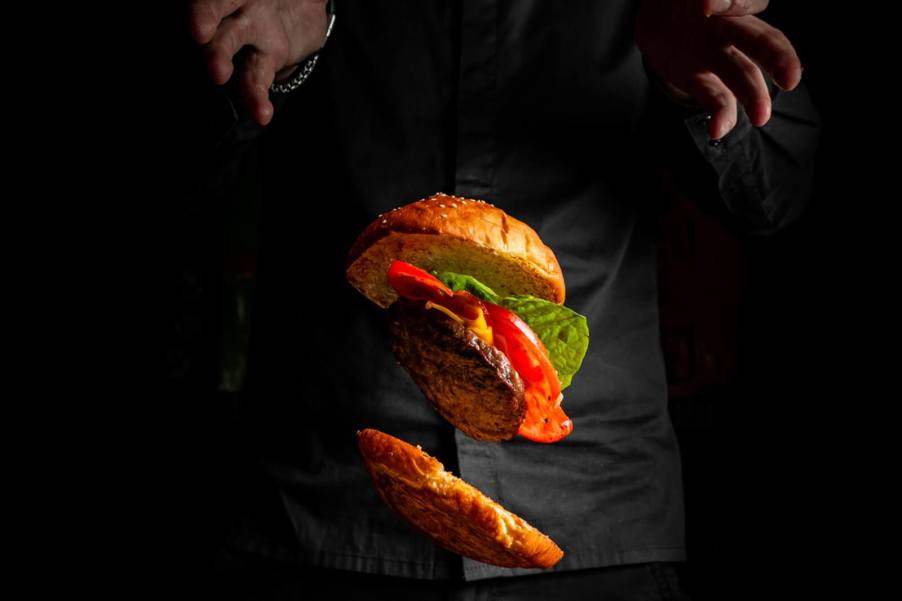 A person throws a cheeseburger on the ground, like a Florida man who tossed a burger out of his car at another person.