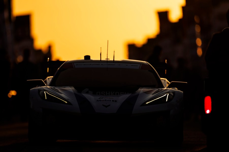 Chevrolet Corvette race car silhouetted against a setting sun.