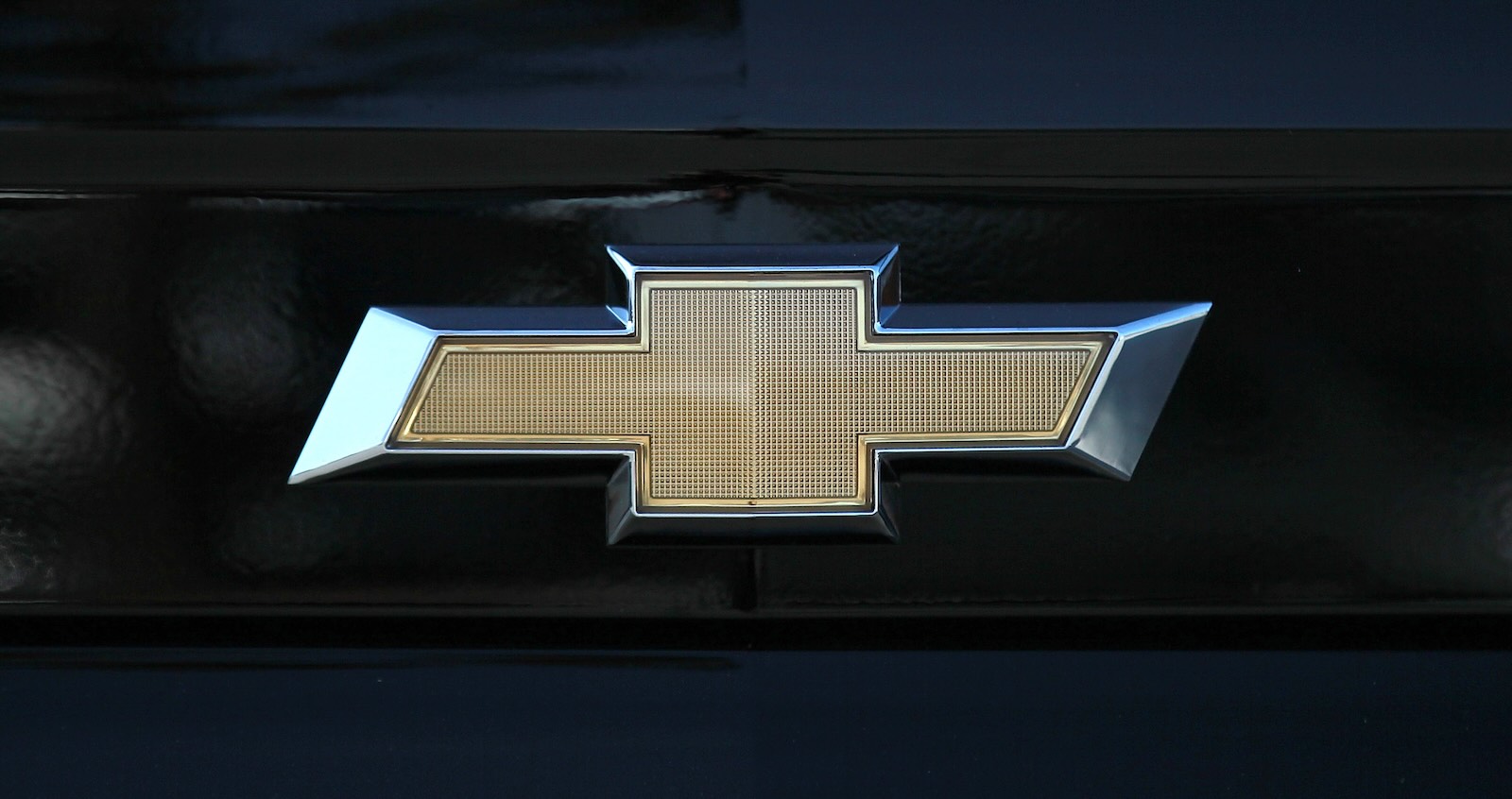 Chevrolet's golden bowtie logo on the grille of a car.