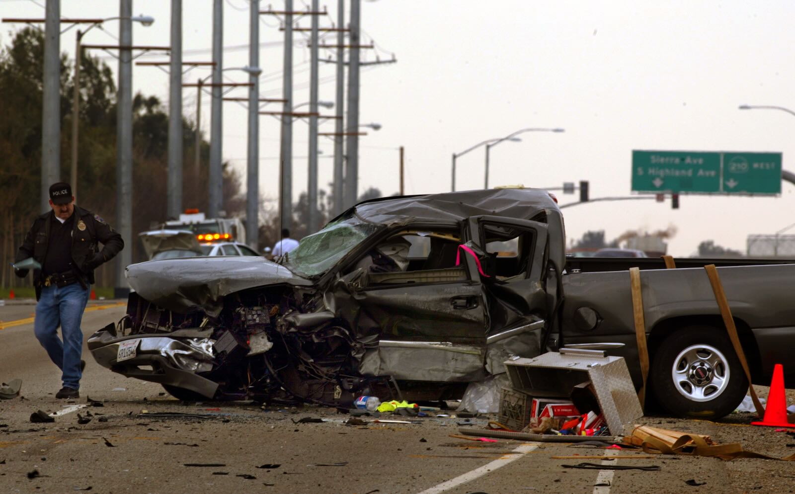 General Motors pickup truck, crashed on the highway with a police officer walking by