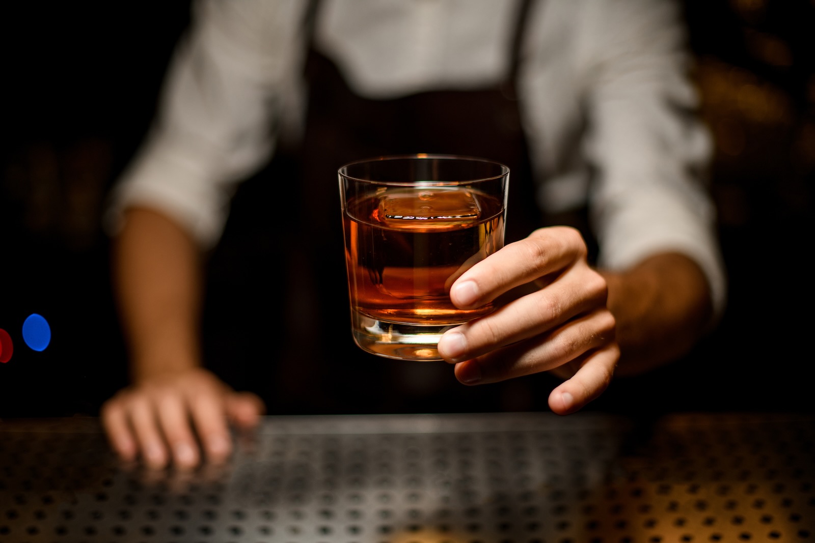 Bartender holds out alcoholic drink at Colorado State Patrol Wet Lab