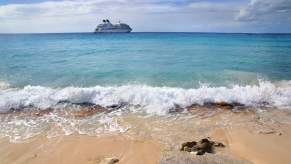 View of a cruise ship leaving an island from the beach.
