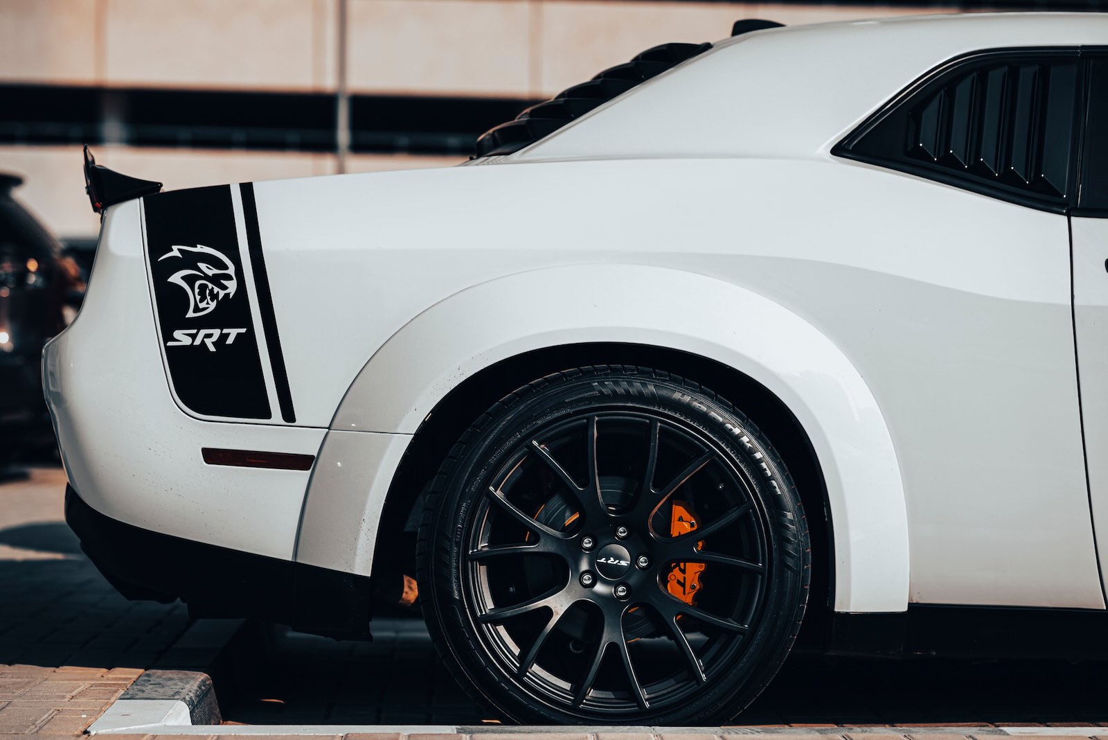 The Hellcat stripe on the back of a white Dodge Challenger muscle car