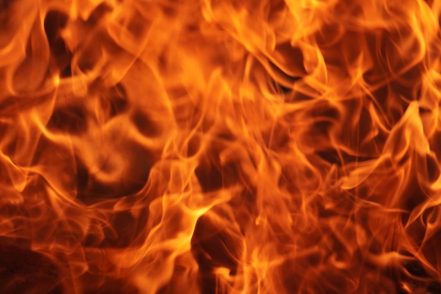 Gasoline fire closeup with orange flames on a black background