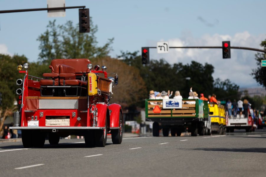 Fire truck and farm tractor driving in a parade.