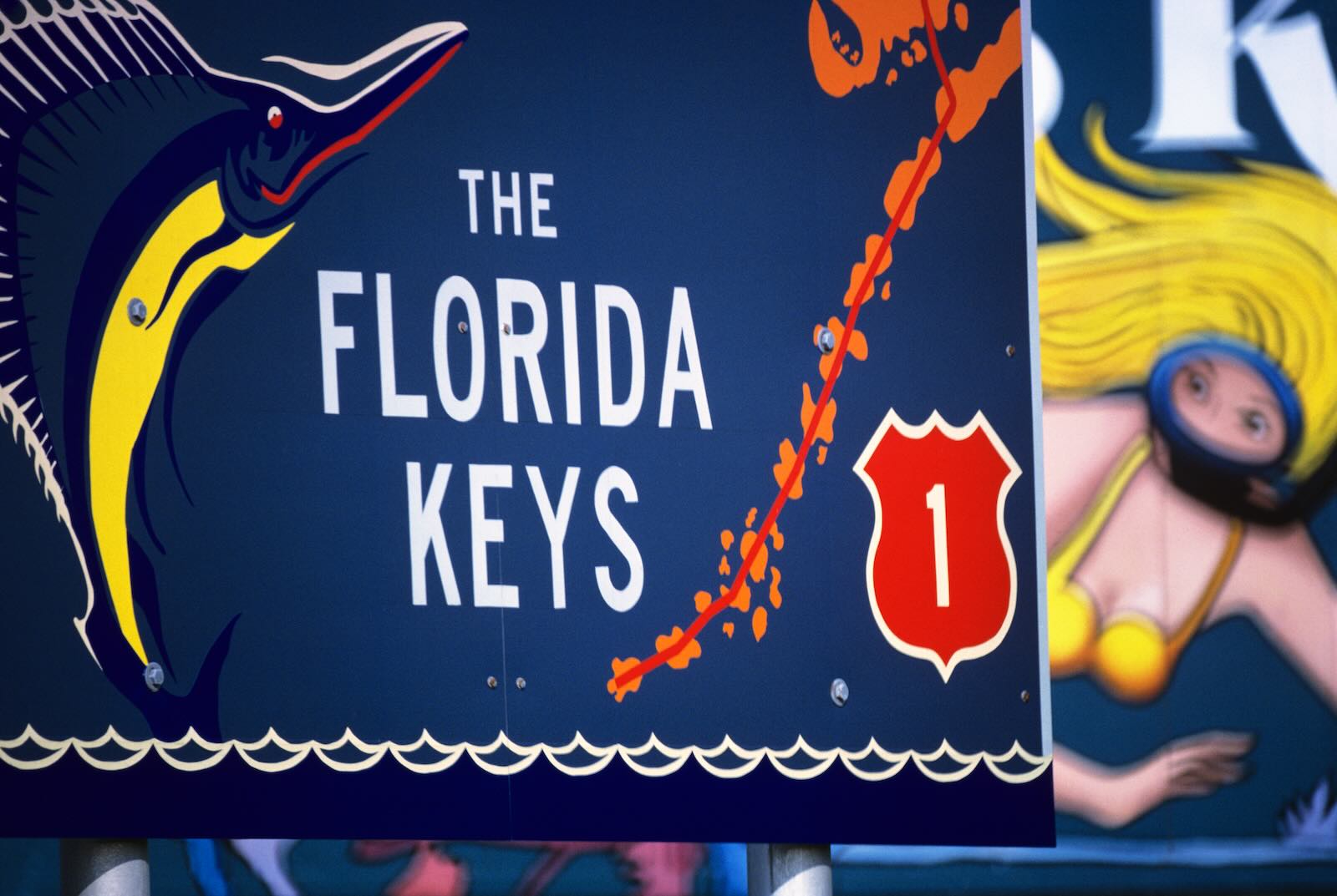 Road sign that says The Florida Keys and has the symbol for US Route 1