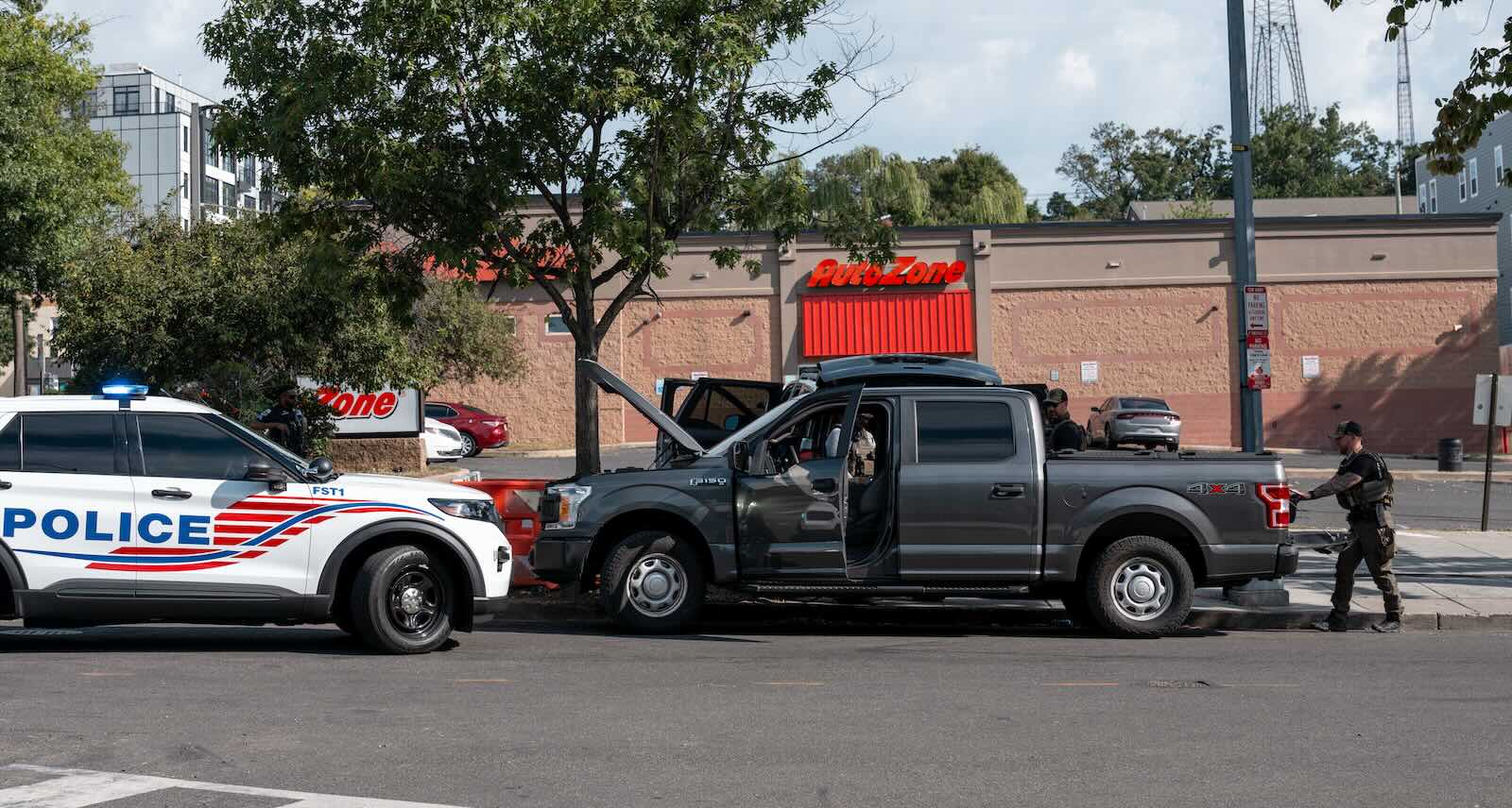 Police officers search a Ford F-150 pickup truck during a traffic stop.