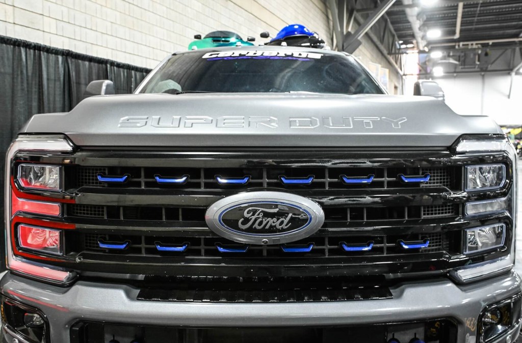 Ford badge on the grille of a Super Duty truck at a car show.
