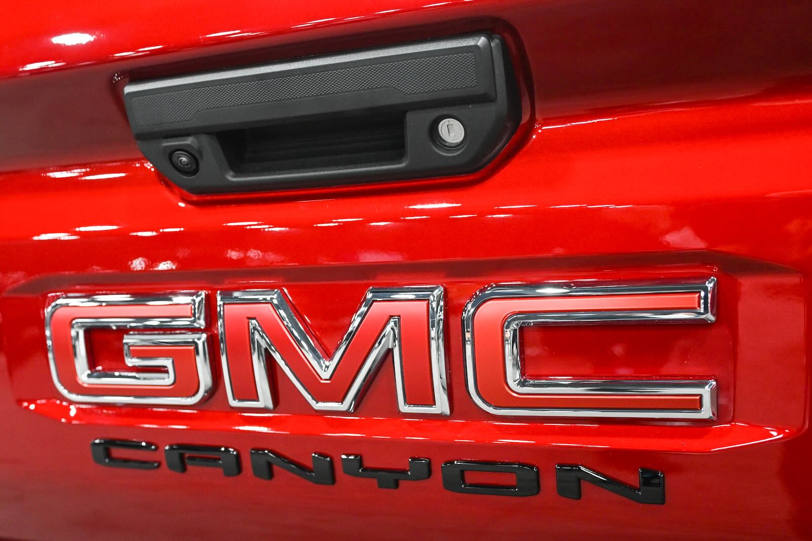 The GMC Canyon logo on the tailgate of a red pickup truck