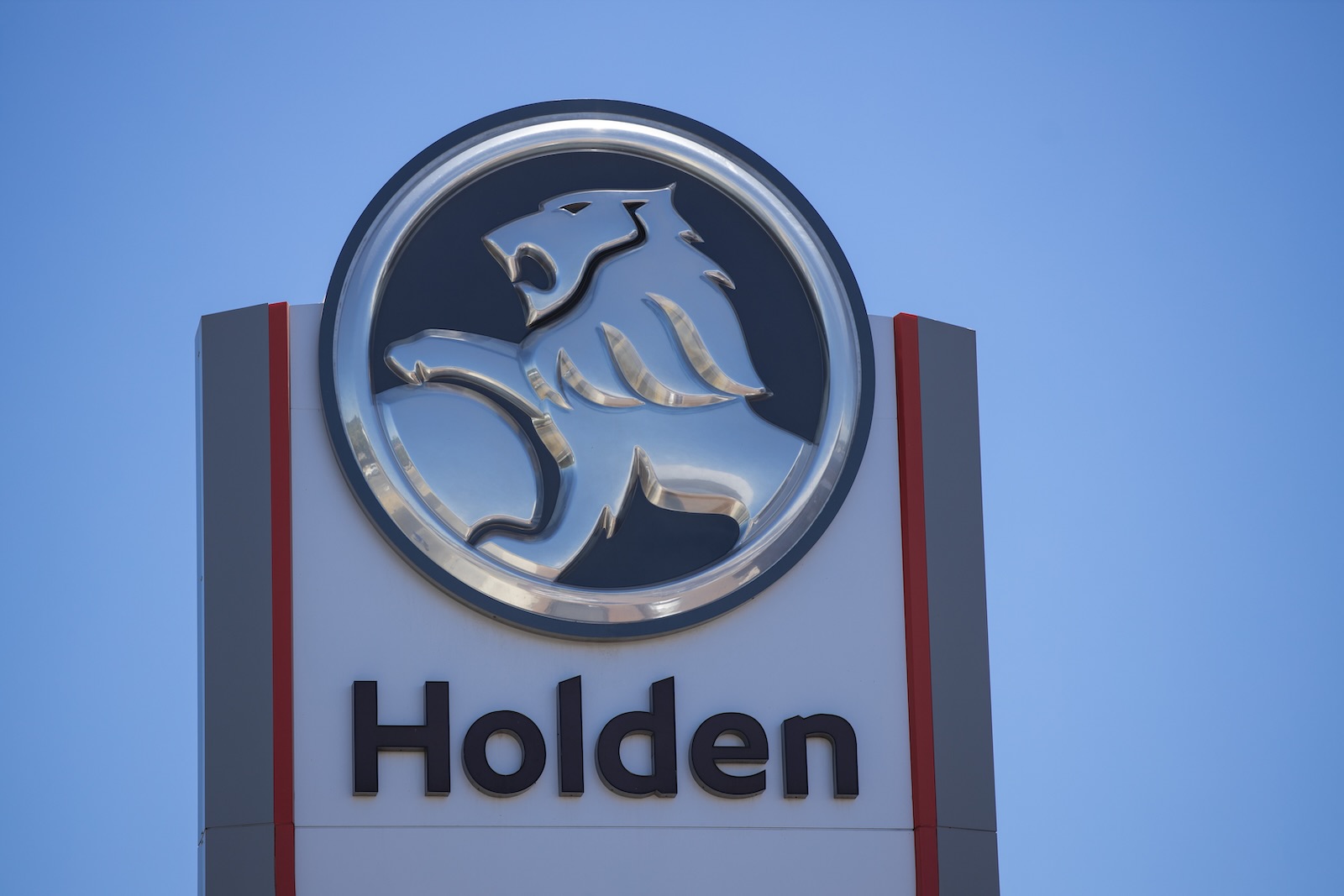The Holden lion logo on top of a sign at a dealership.