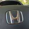 The Honda logo on a Prelude steering wheel.