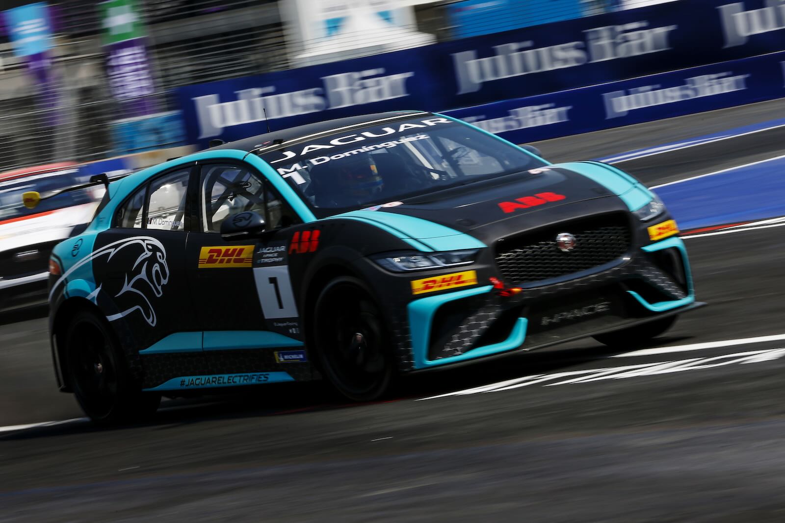 Turquoise and black Jaguar EV race car on a race track