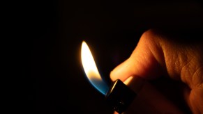 Hands of a Florida man using lighter to burn grandmother's car which he stole