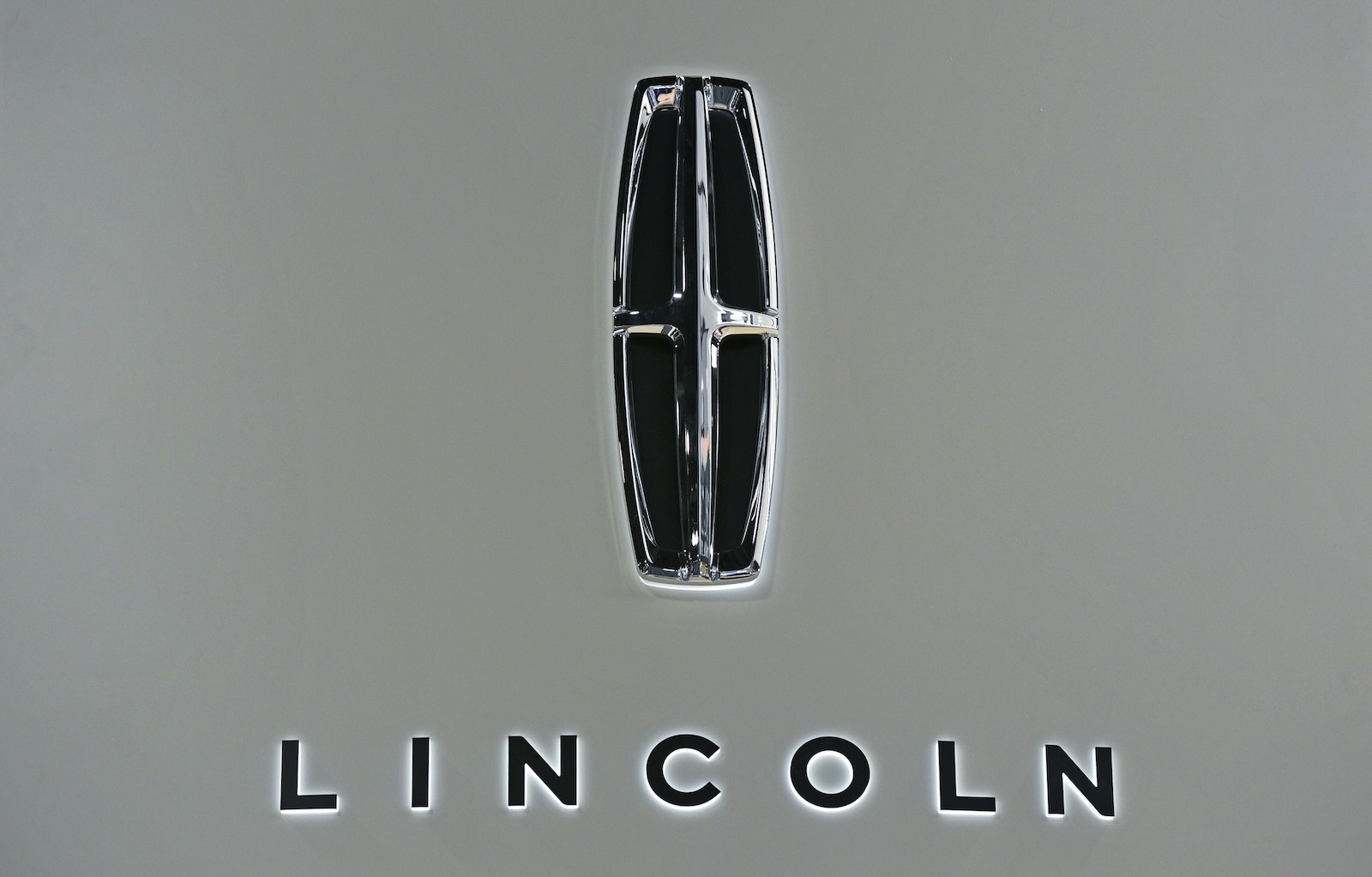 The Lincoln logo and continental four-point star on a white vehicle.
