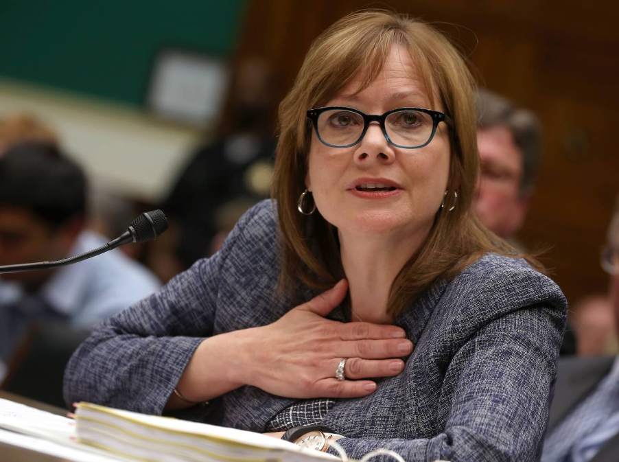 GM CEO Mary Barra holds her hand over her heart while sitting in a Senate committee to testify.