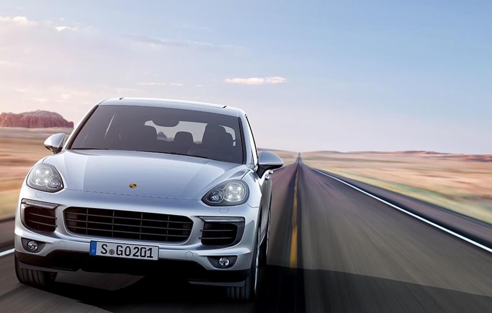 A Porsche Cayenne blasts down an open road.