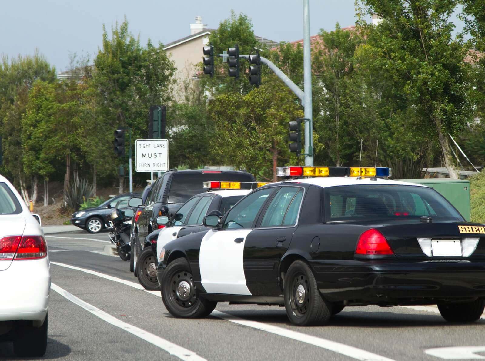 Police cars pull over a motorist for a DWI.