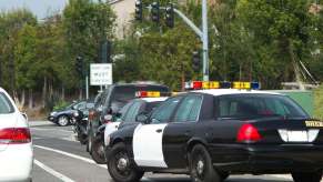 Police cars pull over a motorist for a DWI.