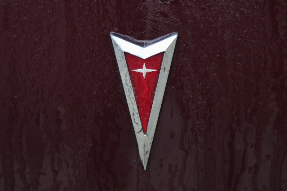 The red arrowhead logo on the hood of a classic Pontiac car.