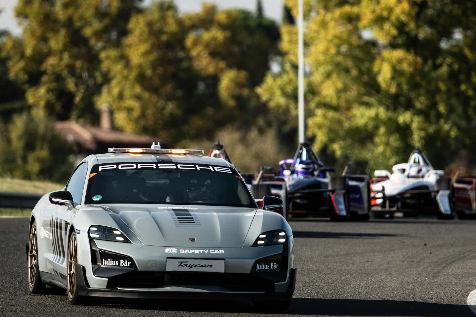 Porsche Taycan luxury EV leading a track full of Formula E race cars