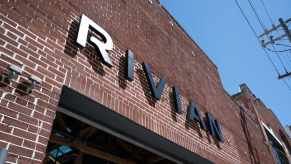 The Rivian logo on the side of a brick building