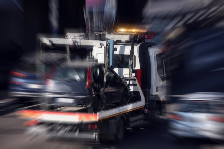 Tow truck hauling a broken car that did not make it to 250,000 miles