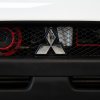 Mitsubishi three-point star logo on a grille at an auto show.